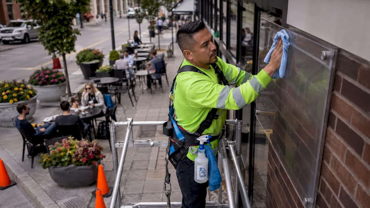 Cleaner wiping large outdoor storefront sign
